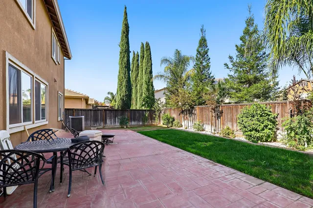 a view of a patio with couches table and chairs and potted plants