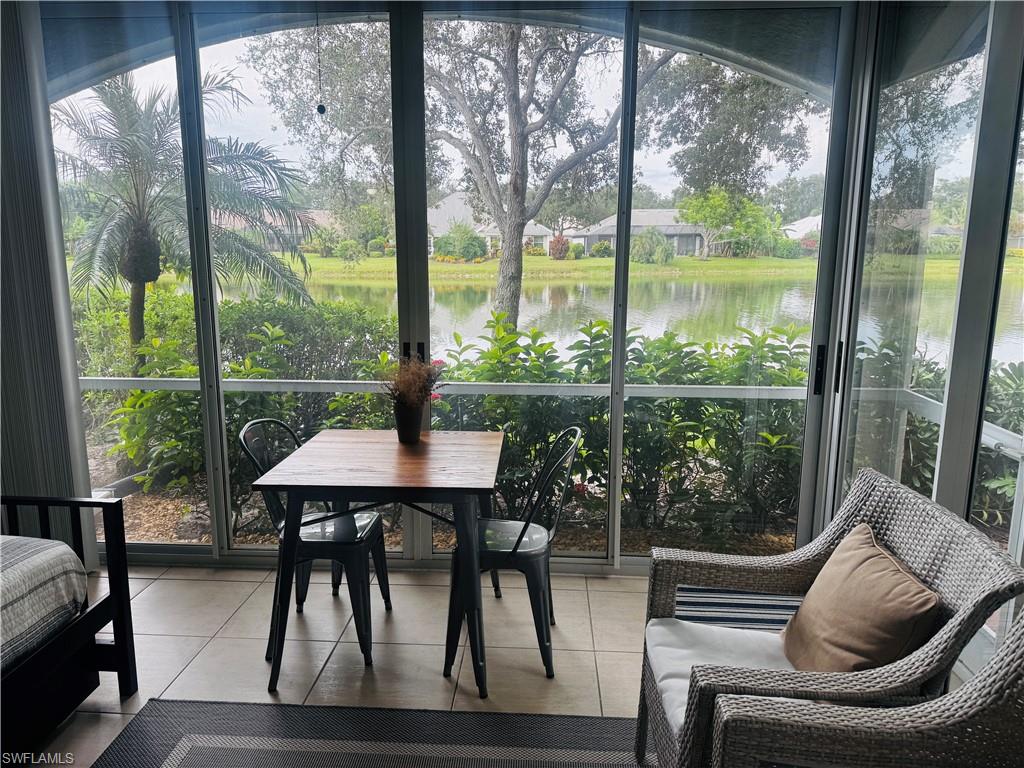 57 Silver Oaks Circle, Unit 103 Naples, FL 34119 - Photo 16 of 22 a view of a living room and floor to ceiling windows and wooden floor
