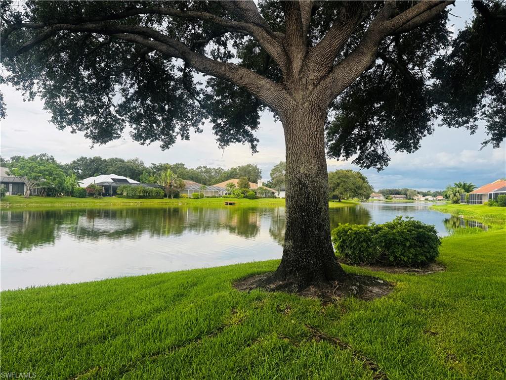 57 Silver Oaks Circle, Unit 103 Naples, FL 34119 - Photo 19 of 22 a view of a lake in a garden