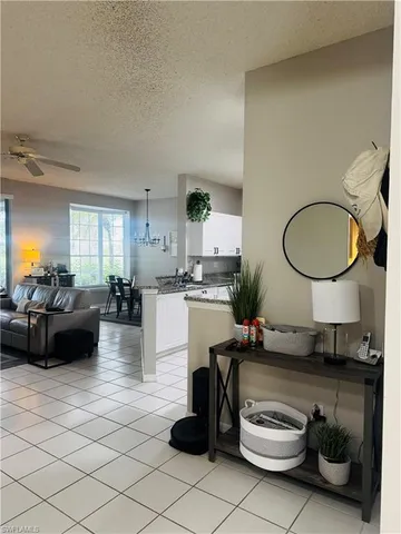 a living room with furniture a mirror and a potted plant