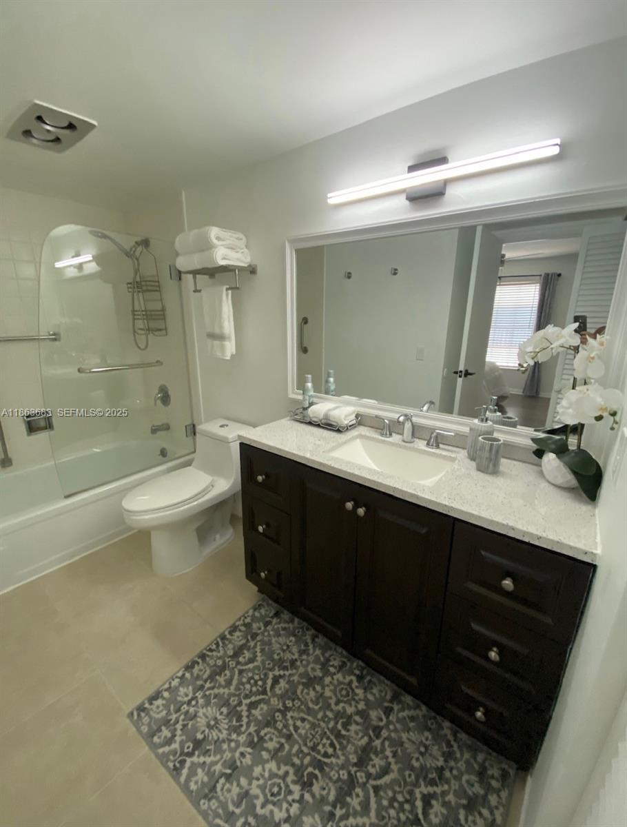 1900 Alamanda Drive, Unit 108 Naples, FL 34102 - Photo 12 of 20 a bathroom with a double vanity sink toilet mirror and bathtub