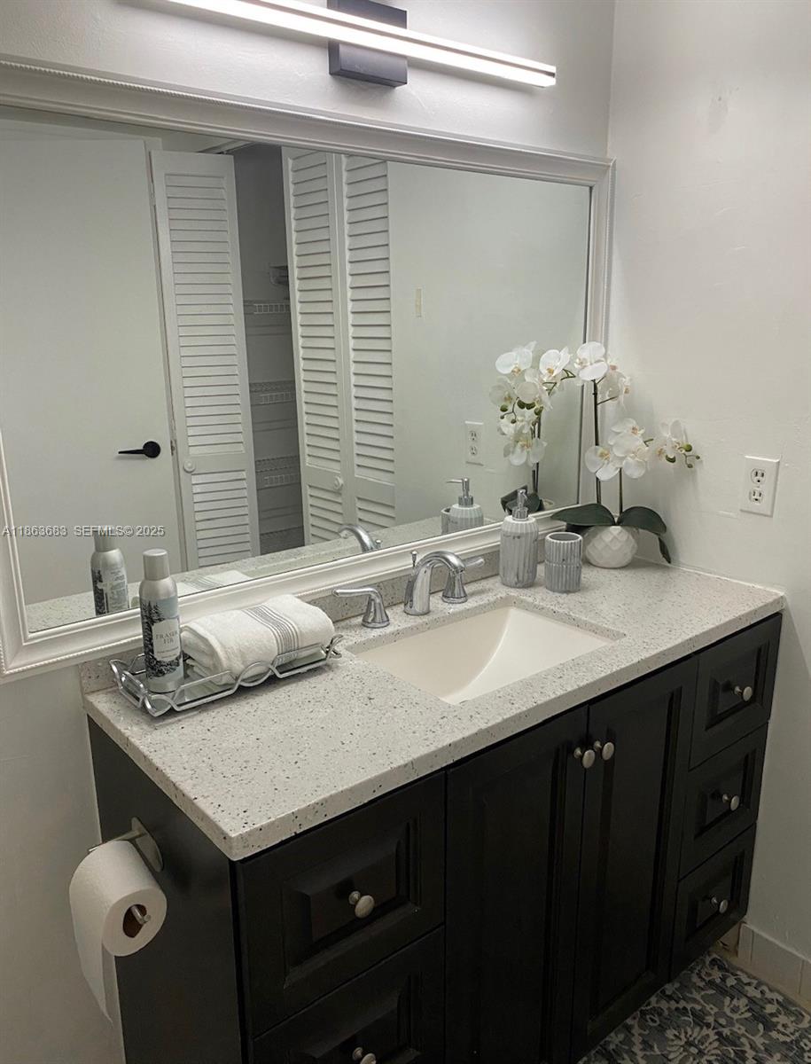 1900 Alamanda Drive, Unit 108 Naples, FL 34102 - Photo 14 of 20 a bathroom with a granite countertop sink and a mirror