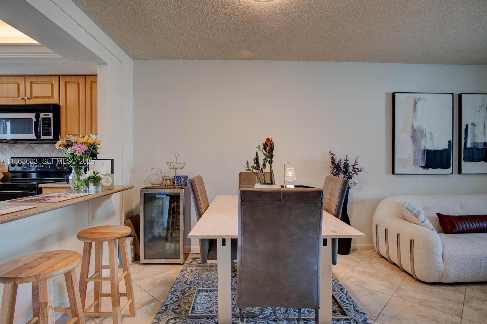 1900 Alamanda Drive, Unit 108 Naples, FL 34102 - Photo 3 of 20 a living room with furniture a flat screen tv and a fireplace