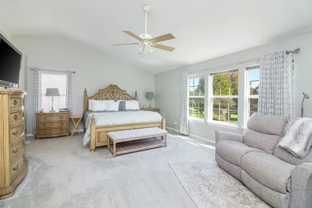 a spacious bedroom with a bed couch and window