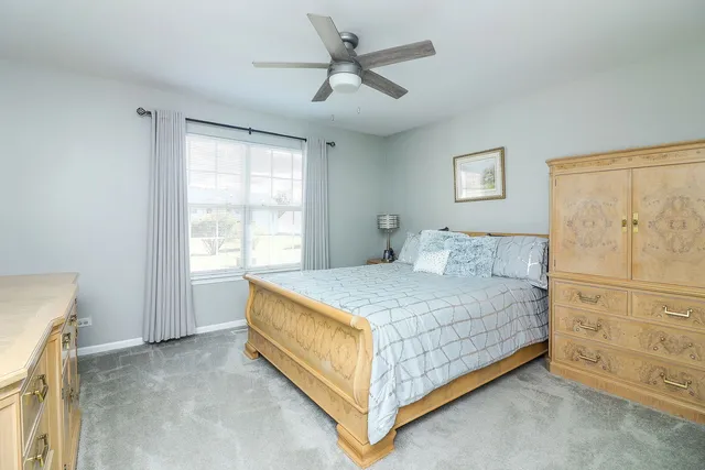 a bedroom with a bed and a ceiling fan