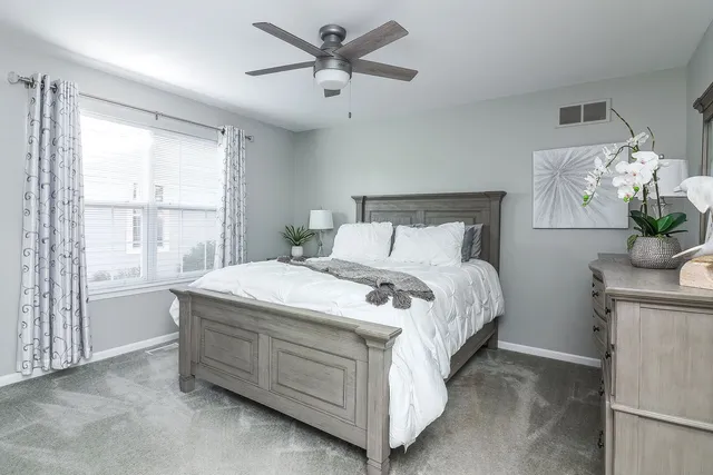 a bed sitting in a spacious bedroom next to a window
