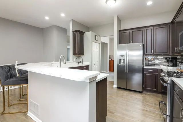 a kitchen with stainless steel appliances cabinets a sink and a refrigerator