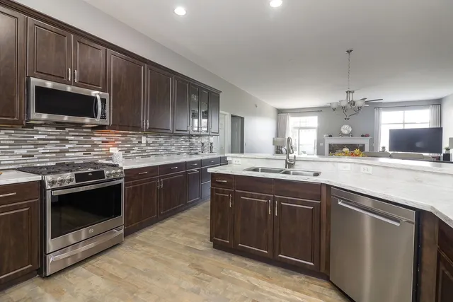 a kitchen with stainless steel appliances granite countertop a stove microwave and sink