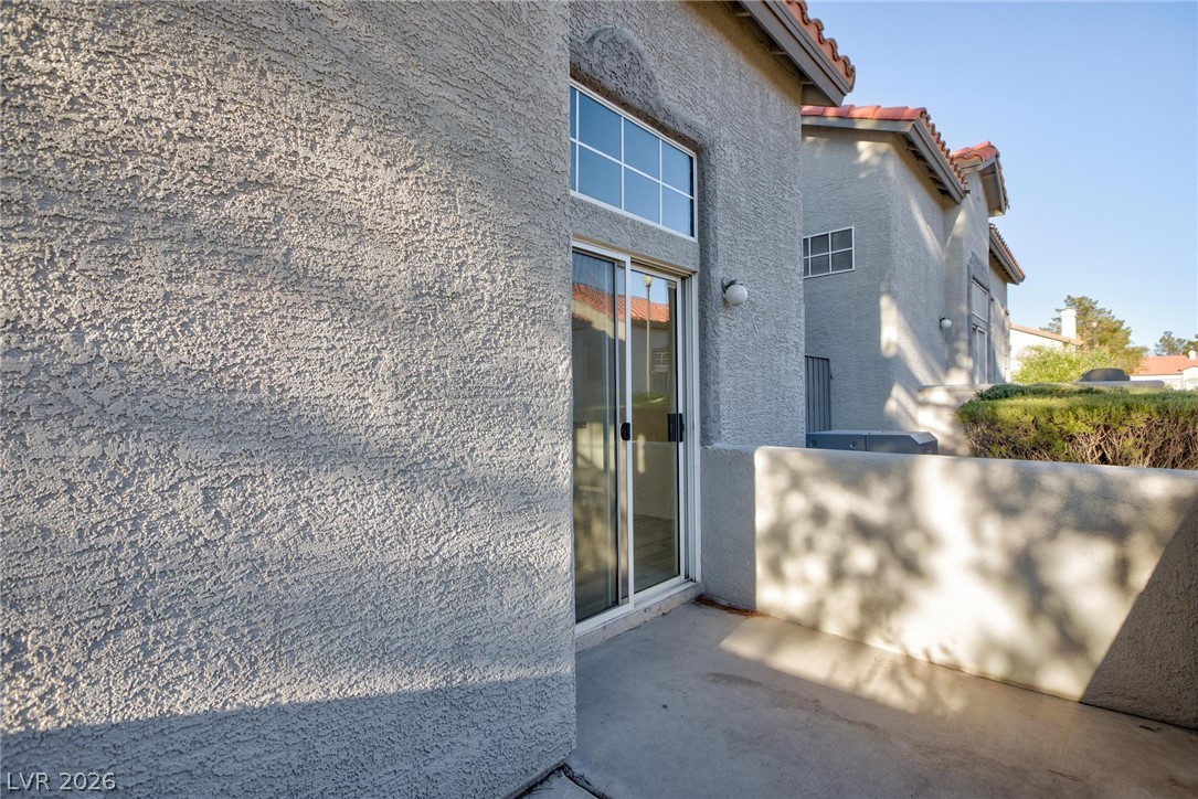 2246 Ramsgate Drive Henderson, NV 89074 - Photo 28 of 36 A private concrete patio offers outdoor access through a glass sliding door and a high window.