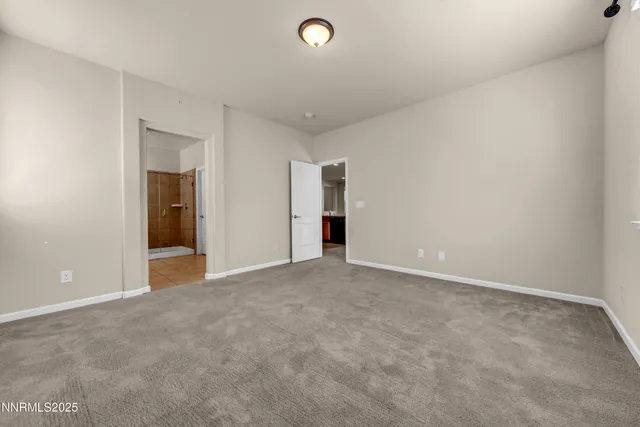 a view of an empty room with closet and fan