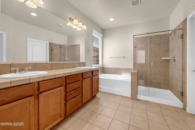 a bathroom with a granite countertop sink mirror and bathtub