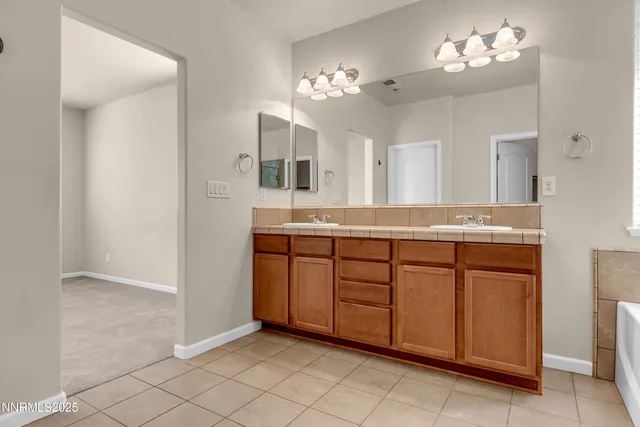 a spacious bathroom with a granite countertop sink a mirror and a vanity