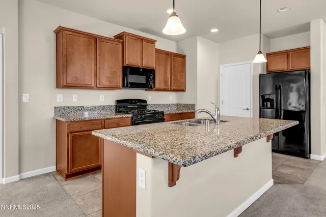 a kitchen with stainless steel appliances granite countertop a sink a stove and a refrigerator
