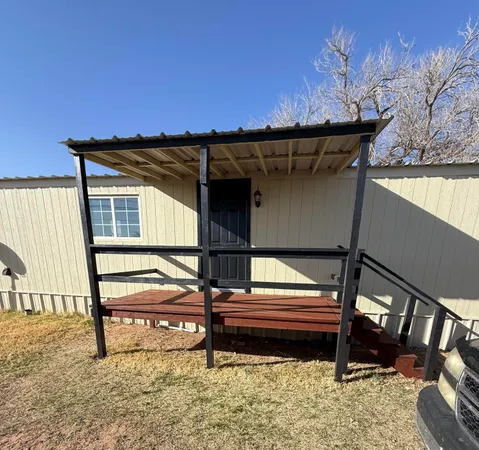 a backyard of a house with wooden fence and a bench