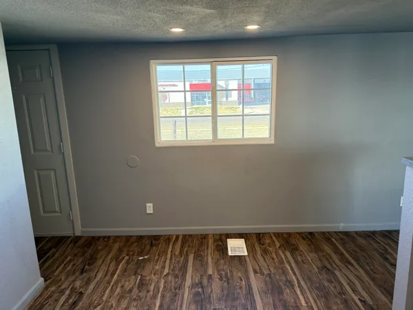 a view of a room with wooden floor and window