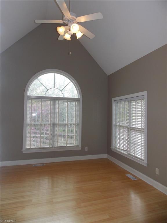 7802 Perthshire Drive Oak Ridge, NC 27310 - Photo 11 of 30 Masterbed bedroom with windows looking out to private wooded area