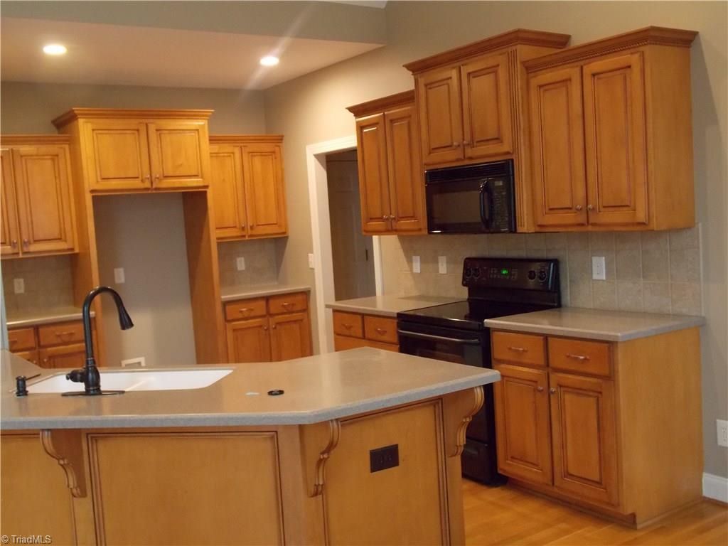 7802 Perthshire Drive Oak Ridge, NC 27310 - Photo 9 of 30 Kitchen has custom cabinets, solid counter tops, and backsplash