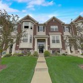 a front view of a house with a yard and trees