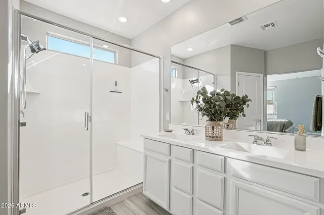 a bathroom with a double vanity sink mirror and shower