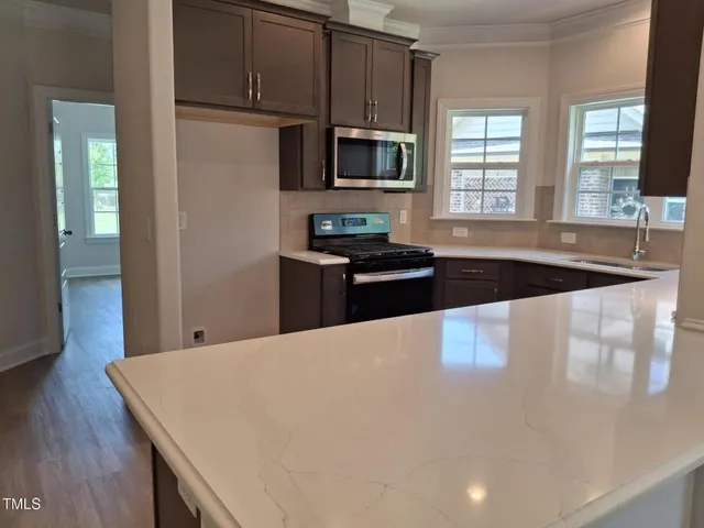 a kitchen with granite countertop a stove and a microwave