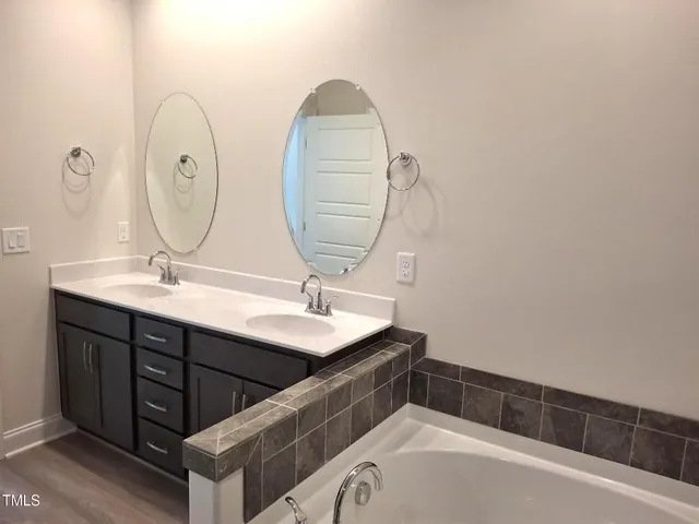 a bathroom with a double vanity sink and a mirror