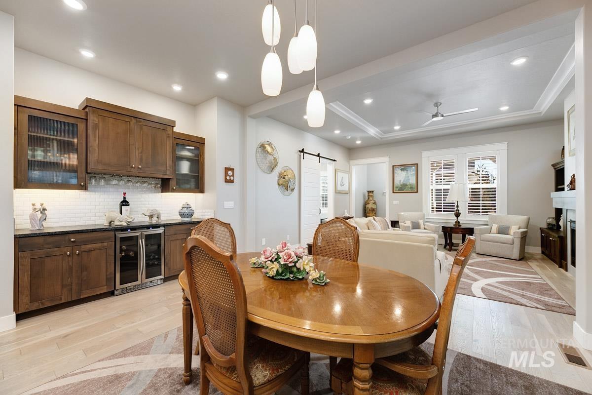 410 West Lockhart Lane Meridian, ID 83646 - Photo 11 of 41 Dining room featuring a barn door, ceiling fan, light wood-style flooring, recessed lighting, and beverage cooler