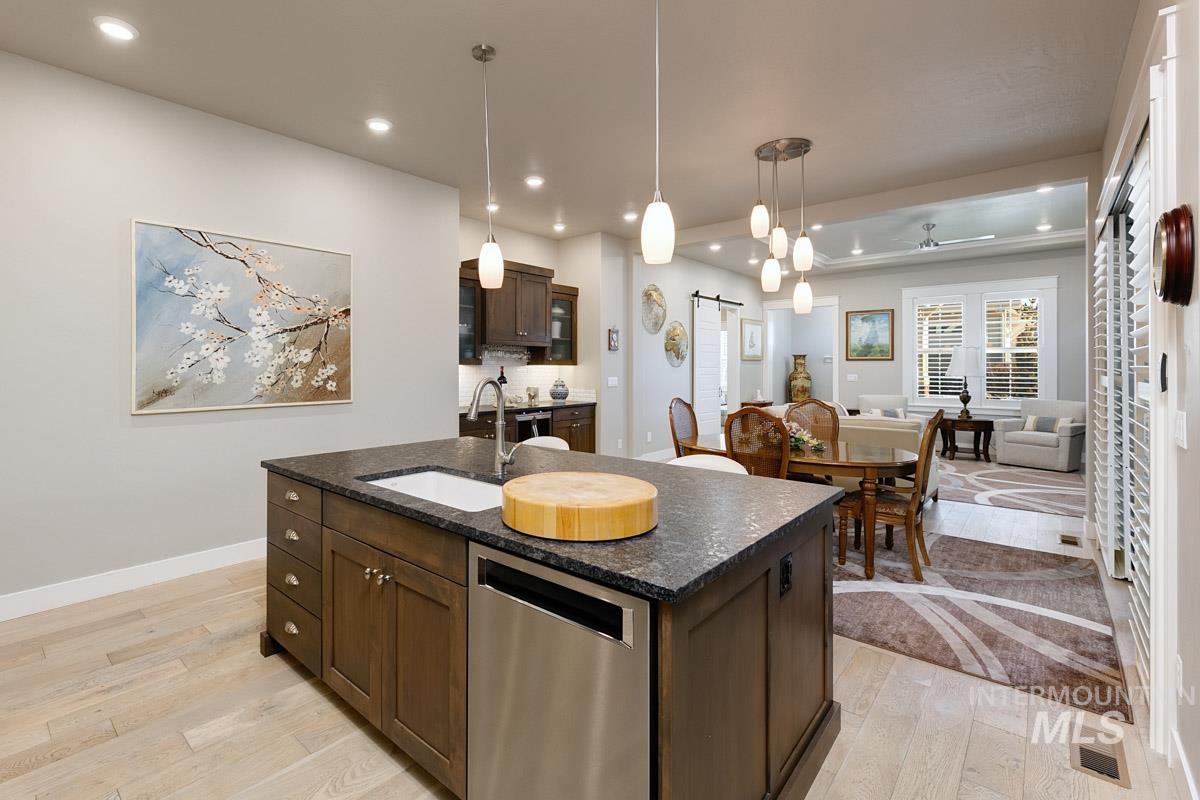410 West Lockhart Lane Meridian, ID 83646 - Photo 40 of 41 Kitchen with light wood-type flooring, dishwasher, dark wood finish cabinets, and open floor plan