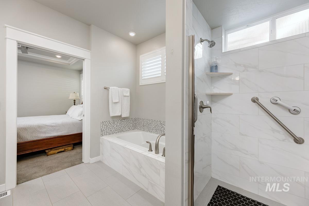 410 West Lockhart Lane Meridian, ID 83646 - Photo 21 of 41 Full bath featuring a garden tub, a shower stall, light tile patterned floors, ensuite bath, and light colored carpet