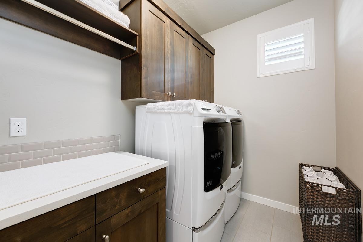 410 West Lockhart Lane Meridian, ID 83646 - Photo 25 of 41 Laundry room with cabinet space, washing machine and clothes dryer, and light tile patterned floors