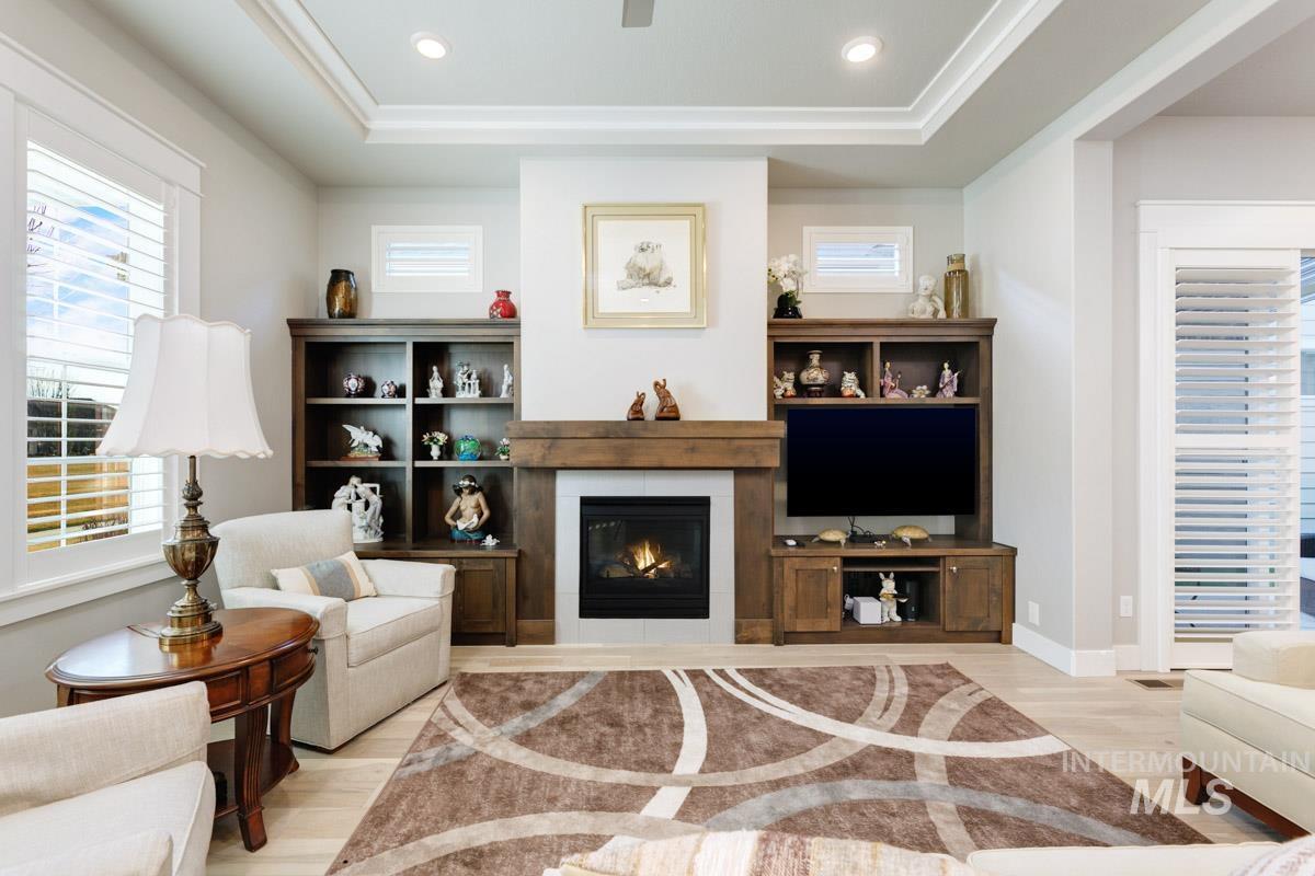 410 West Lockhart Lane Meridian, ID 83646 - Photo 9 of 41 Living room with healthy amount of natural light, light wood finished floors, recessed lighting, a raised ceiling, and a glass covered fireplace