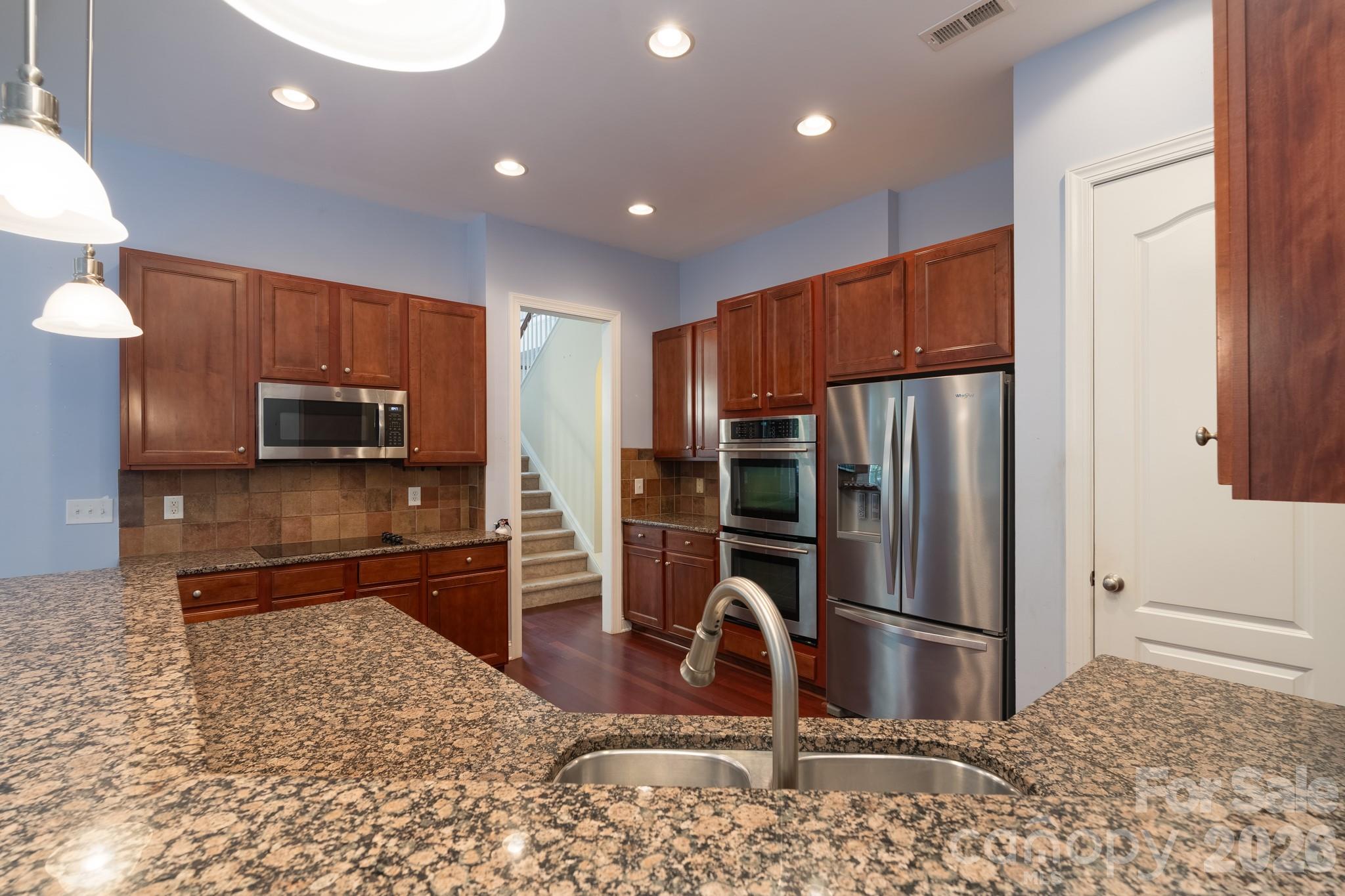 878 Treasure Court Fort Mill, SC 29708 - Photo 4 of 48 a kitchen with kitchen island granite countertop a refrigerator and a sink