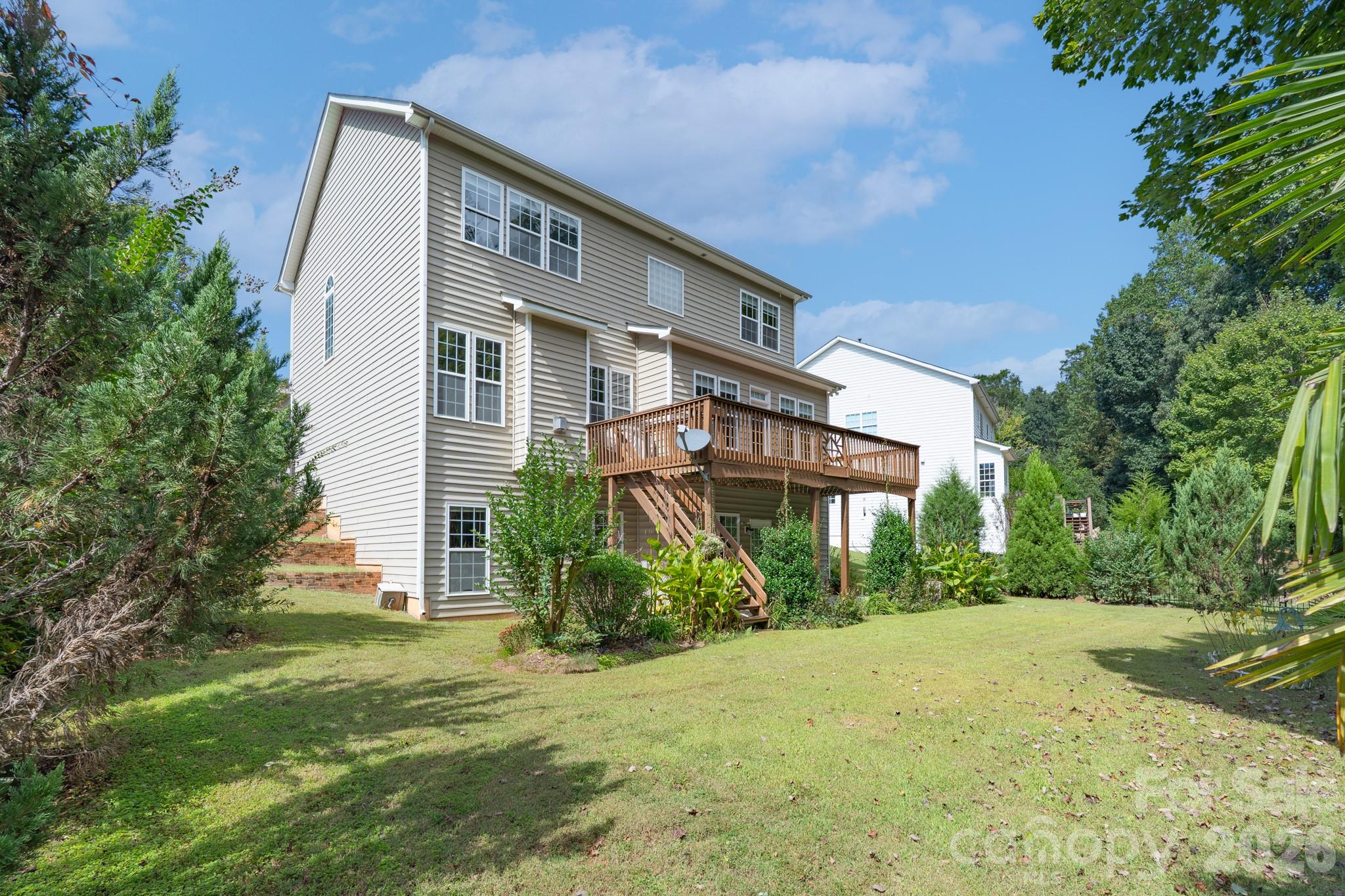 878 Treasure Court Fort Mill, SC 29708 - Photo 44 of 48 a view of a brick house with a big yard and large trees