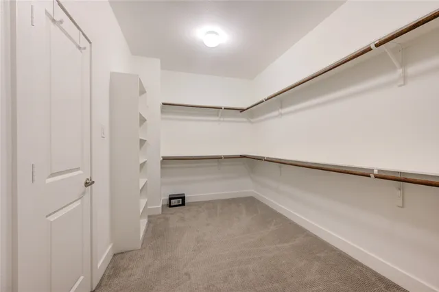 a view of walk in closet with empty racks