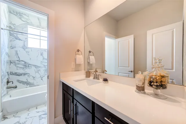 a bathroom with a tub sink and mirror