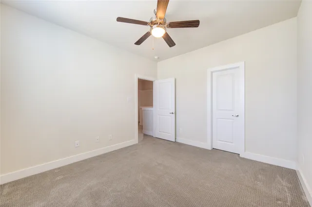 an empty room with chandelier fan
