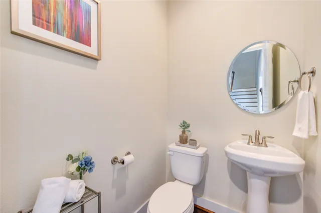 a bathroom with a toilet a sink and mirror