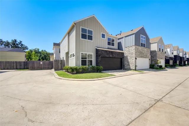 a view of a white house with a big yard and large trees