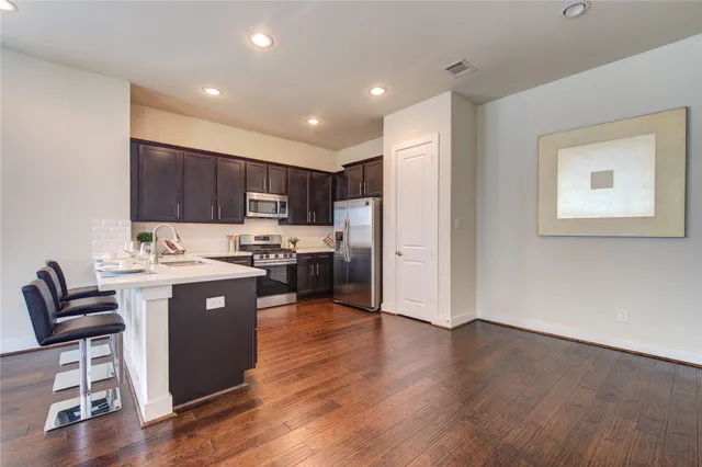 a view of kitchen with wooden floor and electronic appliances