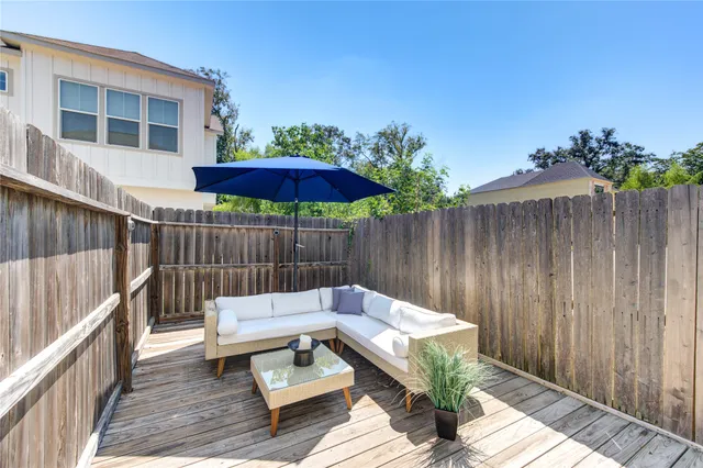 a view of a backyard with a patio and wooden fence