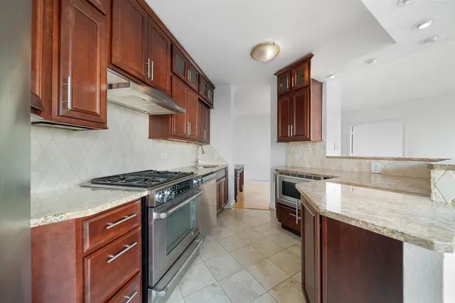 a kitchen with stainless steel appliances granite countertop a sink and a stove