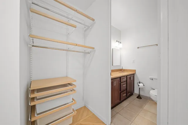 a view of walk in closet with clothes and shoes