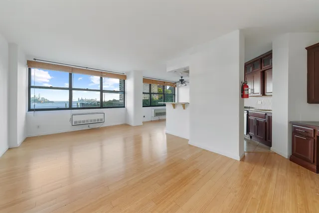 a view of empty room with wooden floor and fireplace