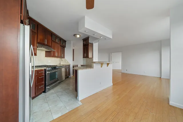 a kitchen with granite countertop stainless steel appliances a stove sink and cabinets