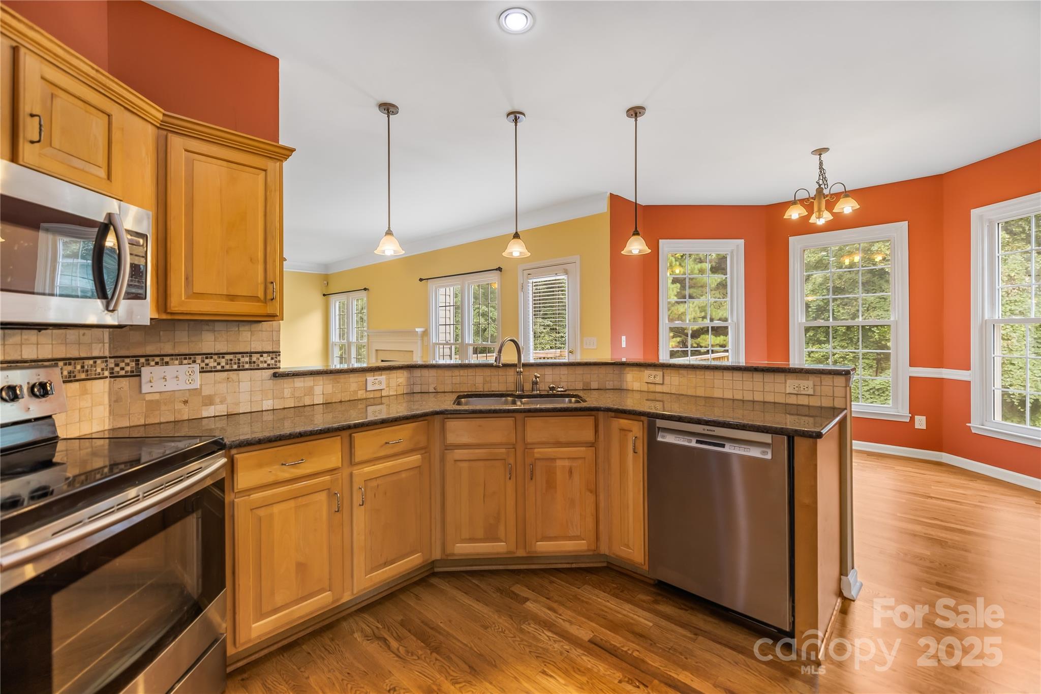 17112 Cambridge Grove Drive Huntersville, NC 28078 - Photo 12 of 44 a kitchen with stainless steel appliances granite countertop a stove a sink and a wooden cabinets