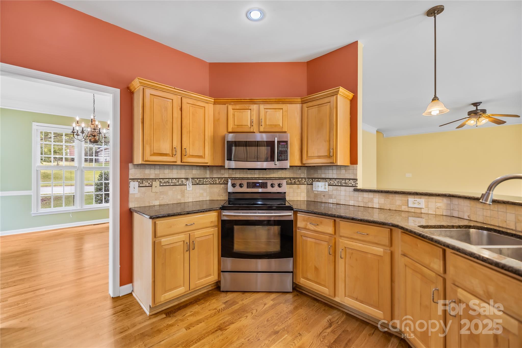 17112 Cambridge Grove Drive Huntersville, NC 28078 - Photo 15 of 44 a kitchen with granite countertop a stove a sink and a microwave