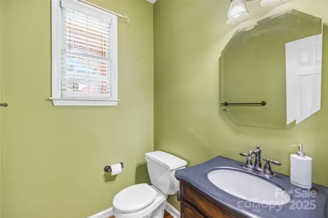 a bathroom with a granite countertop toilet sink and mirror