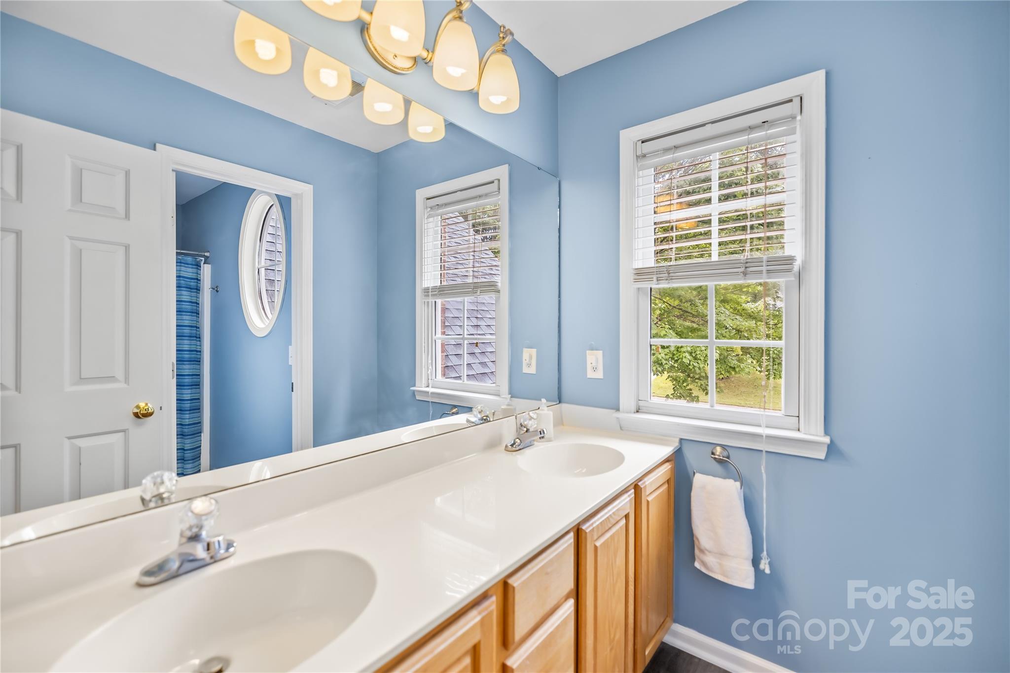 17112 Cambridge Grove Drive Huntersville, NC 28078 - Photo 26 of 44 a bathroom with a sink a vanity and a large mirror