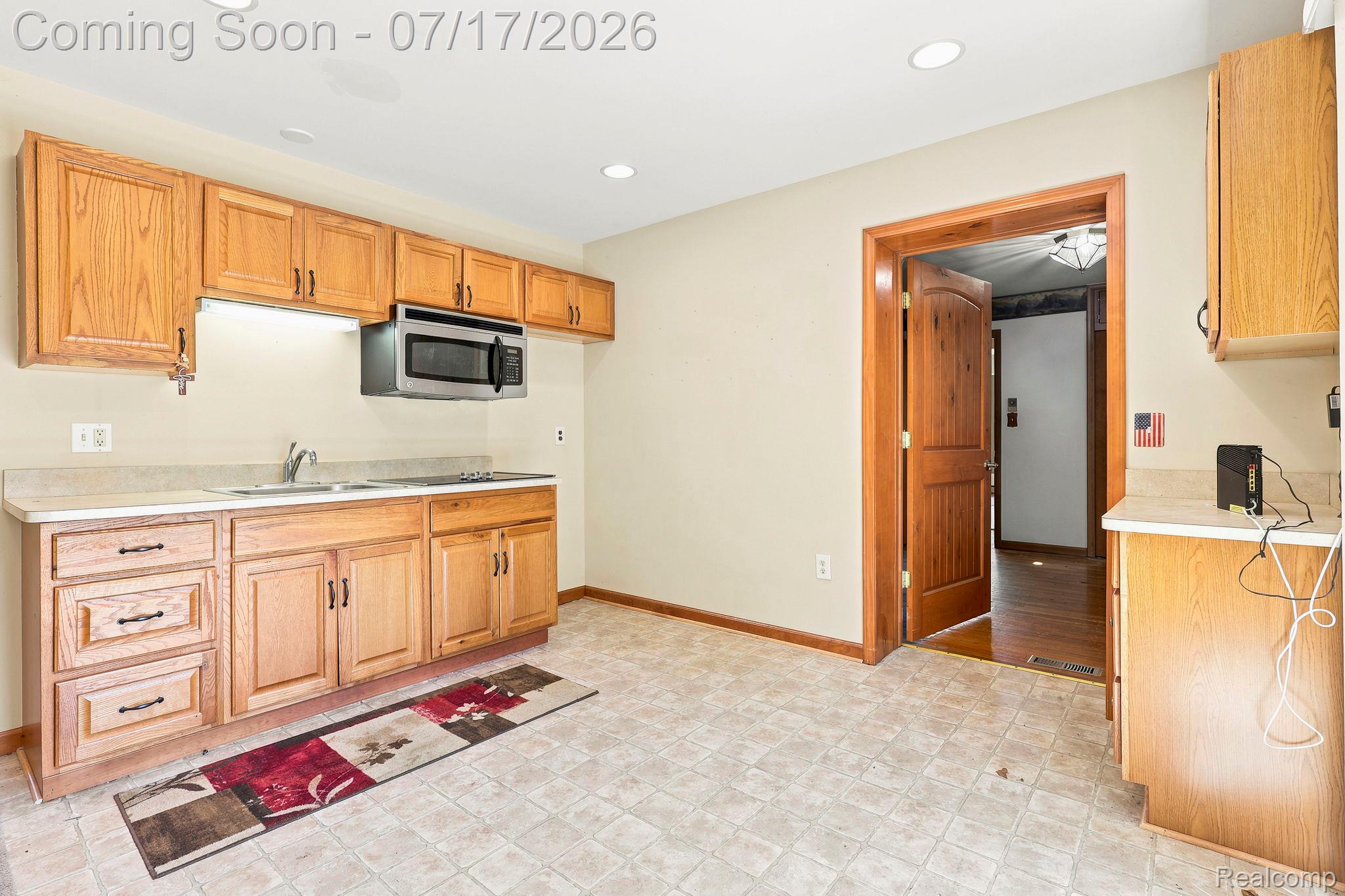 9805 Dolan Road Columbus, MI 48063 - Photo 19 of 39 Kitchen featuring wood cabinetry, laminate countertops, stainless steel microwave, recessed ceiling lighting, and tile-finish flooring