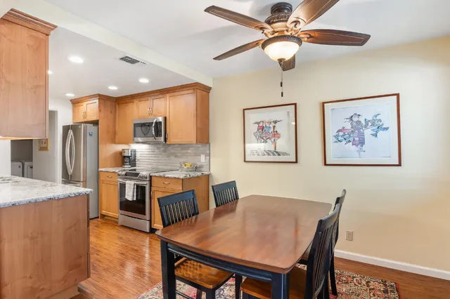 a living room with stainless steel appliances kitchen island granite countertop furniture and a chandelier