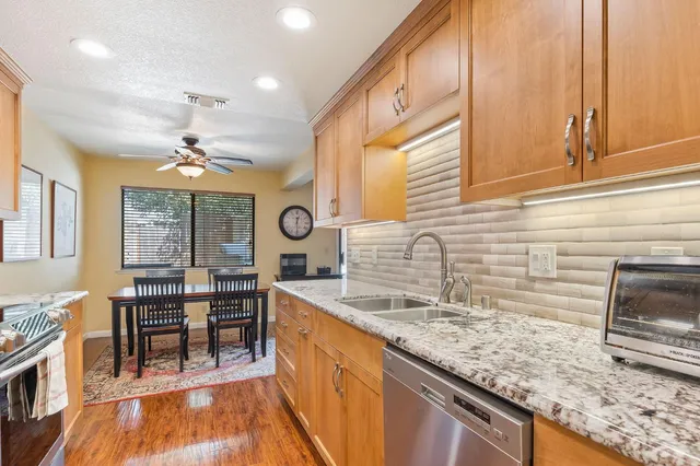a kitchen with stainless steel appliances granite countertop a sink stove and cabinets